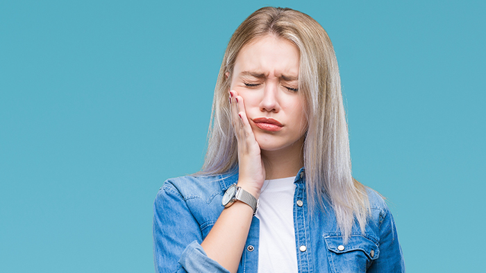 Young Blonde Woman Over Isolated Background Touching Mouth With Hand With Painful Expression Because Of Toothache Or Dental Illness On Teeth. Dentist Concept.